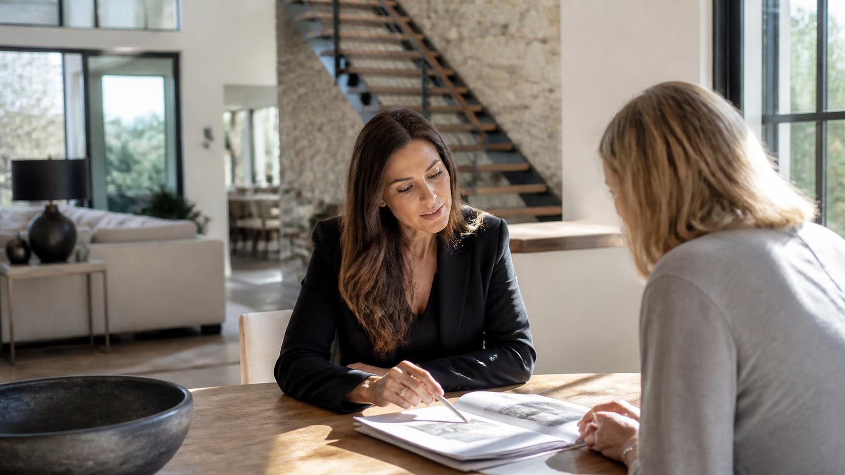 Real estate professional reviewing documents with a client during a home buying or selling consultation, illustrating the importance of professional expertise and verifying information.